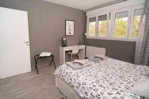 una camera con letto, scrivania e finestre di Apartman Ina a Osijek