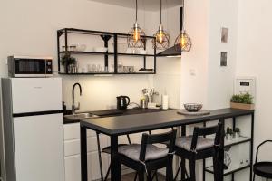 a kitchen with a table and chairs and a refrigerator at Apartman Ina in Osijek