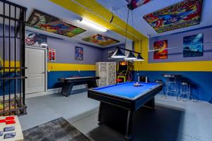 a pool table in a room with colorful walls at Moonlight Ridge - 5 bed ChampionsGate Resort pool home in Davenport