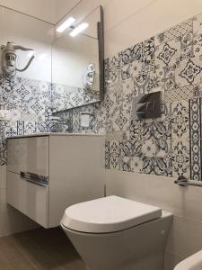La salle de bains est pourvue de toilettes et de papier peint noir et blanc. dans l'établissement Florí, à Reitani