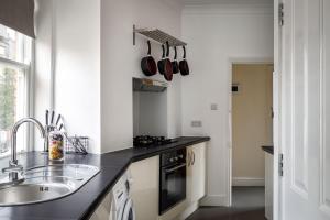 One Bedroom Apartment in Marylebone في لندن: مطبخ مع حوض و كونتر توب