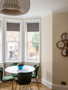 One Bedroom Apartment in Marylebone في لندن: غرفة طعام مع طاولة وكراسي ونوافذ
