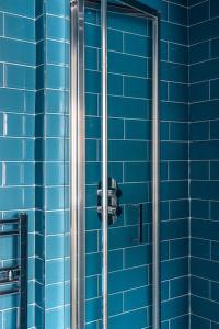 ein blau gefliestes Bad mit Dusche in einem Gebäude in der Unterkunft One Bedroom Apartment in Marylebone in London