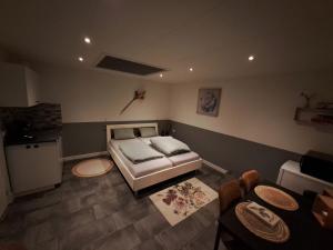 ein Schlafzimmer mit einem Bett und einem Tisch sowie eine Küche in der Unterkunft studio ' aan de Nieuwstraat ' Sint Annaland in Sint-Annaland
