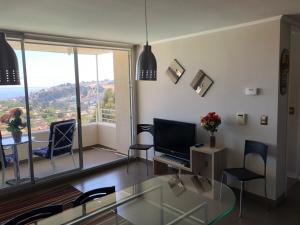 un salon avec une table en verre et une télévision dans l'établissement Dpto tipo Resort, à Viña del Mar