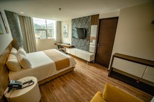 une chambre d'hôtel avec un lit et une télévision dans l'établissement Hotel La Peonía, à La Paz