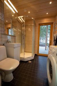 uma casa de banho com um WC, um chuveiro e um lavatório. em Rantarovio em Alvajärvi