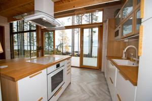 a kitchen with white appliances and a large window at Rantarovio in Alvajärvi +38 photos