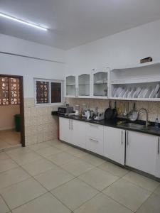 a kitchen with white cabinets and a tile floor at Meshaal heights in Mombasa