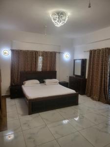 a bedroom with a bed and a flat screen tv at Meshaal heights in Mombasa