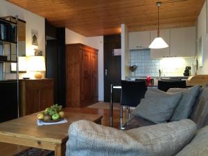 ein Wohnzimmer mit einem Sofa und einem Tisch mit einer Obstschale in der Unterkunft Apartment Eglantine in Crans-Montana