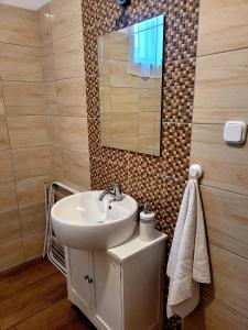 a bathroom with a sink and a mirror at Olivér Apartmanház in Balatonlelle