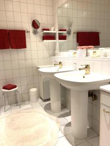 a white bathroom with two sinks and a mirror at Hotel Der Schwan in Einbeck