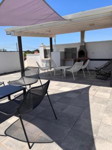 un patio avec des chaises et un parasol sur le toit dans l'établissement Florí, à Reitani