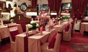 un comedor con mesas blancas y sillas con flores en Hotel Der Schwan en Einbeck