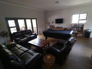 sala de estar con sofás y mesa de billar en 2 Bedroom Guest Suite at A-frame Glengariff Beach, en Glen Eden