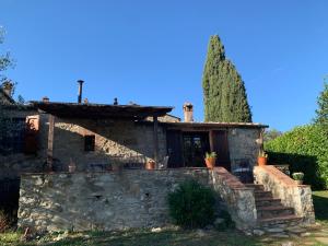 ein Haus mit einer Steinmauer und einem Baum in der Unterkunft Casa VANINA-self check-in in Castellina in Chianti