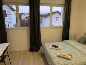 a bedroom with a bed and a large window at Villa Tenjin Chambre 11 in Bondy