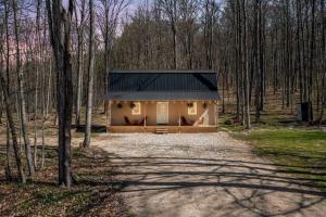 a small house in the middle of a forest at Hygge Up North Bungalow in Bellaire