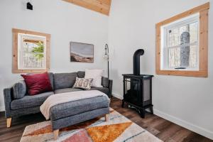 a living room with a couch and a stove at Hygge Up North Bungalow in Bellaire