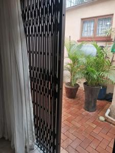 a black gate in front of a house with plants at JoThams Bed & Breakfast or Self-catering in Durban