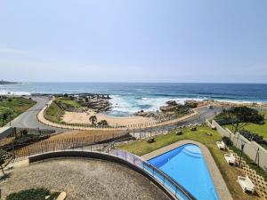 a view of a beach and a swimming pool and the ocean at Blue Whale in Margate