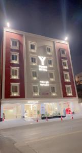 a large building with a store in front of it at night at فندق واي هوتل in Abha