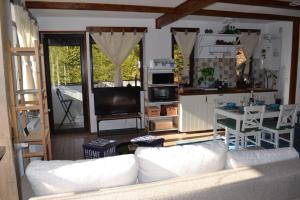 アズガにあるStudio Mirage@Snow Residence (ski & forest)のリビングルーム(白いソファ付)、キッチンが備わります。