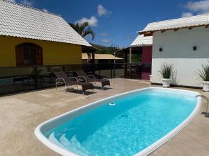 a swimming pool in front of a house at Pousada Rancho na Serra in Espera Feliz