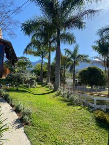 a park with palm trees and a fence at Pousada Rancho na Serra in Espera Feliz