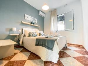 1 dormitorio con 1 cama y suelo a cuadros en APARTAMENTOS FERNANDO III EL SANTO, en Baeza