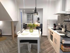 a kitchen and dining room with a white table and chairs at APARTAMENTOS FERNANDO III EL SANTO in Baeza