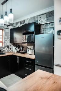 a kitchen with black cabinets and a stainless steel refrigerator at Nelspruit 66 At Riverside Estate in Boschrand