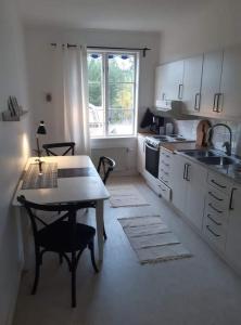 uma cozinha com uma mesa, uma mesa e um lavatório em Bograngen LGH D em Brograngen