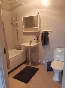 uma casa de banho com um lavatório, uma banheira e um WC. em Bograngen LGH D em Brograngen