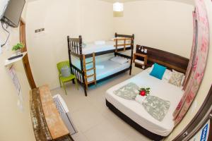 Habitación pequeña con 2 camas y mesa. en Pousada Paraíso Tropical, en Penha
