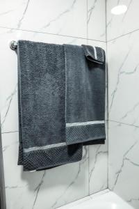 Nelspruit 66 At Riverside Estate في Boschrand: منشفة سوداء معلقة على الحائط في الحمام