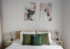 a bedroom with a bed with two paintings on the wall at LINA - PG, Moraca River Apartment in Podgorica