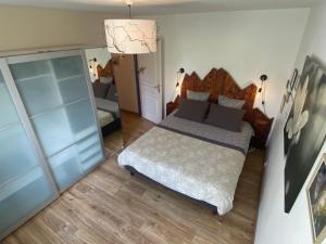 una piccola camera con letto e specchio di La petite marmite du lac de Vouglans a Pont-de-Poitte