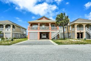ein großes Haus mit einer Palme davor in der Unterkunft Gulf Shores Family Home with Deck, Walk to Beach! in Gulf Shores