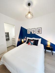 um quarto com uma cama branca e uma parede com um toque azul em Le Cobalt - Hypercentre - Gare - Netflix em Toulouse