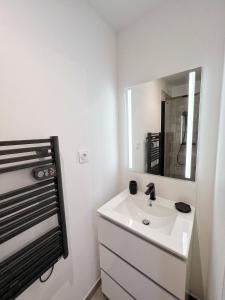 uma casa de banho branca com um lavatório e um espelho em Le Cobalt - Hypercentre - Gare - Netflix em Toulouse