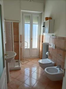 łazienka z 2 umywalkami, toaletą i prysznicem w obiekcie Dimora Palma di Barolo w mieście Barolo