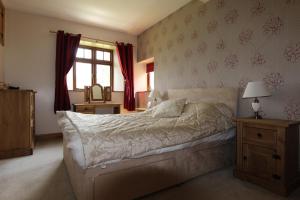 1 dormitorio con cama, ventana y espejo en The Granary en Barnstaple
