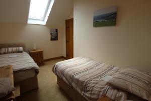 a bedroom with two beds and a window at The Granary in Barnstaple