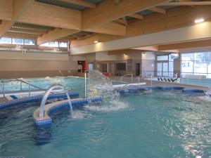 a large indoor swimming pool with a water slide at appartement avec balcon terrasse plein sud proche lac et centre ville wifi in Gérardmer