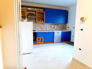 a kitchen with blue cabinets and a white floor at Casa di Tatiana!!! in Castel del Piano