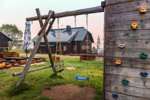 a wooden playground with swings in front of a house at Hájenka Knížecí Pláně in Borová Lada