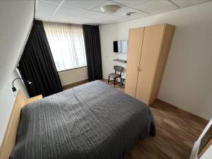 Katwijk aan ZeeにあるAppartement 5のベッドルーム1室(ベッド1台、キャビネット付)