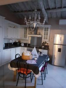 a kitchen with a table with chairs and a refrigerator at Splendido rustico shabby in Capannori